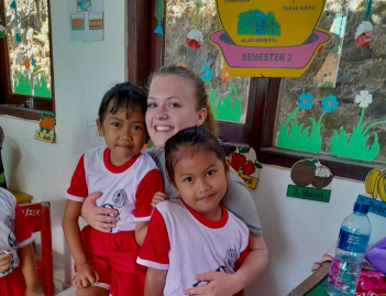Lynn in de Indonesische kleuterschool met twee kleuters in haar armen