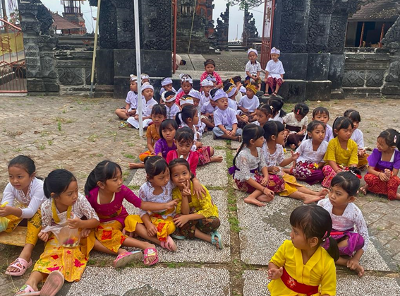 Indonesische kleuters zitten op de grond op het schoolplein