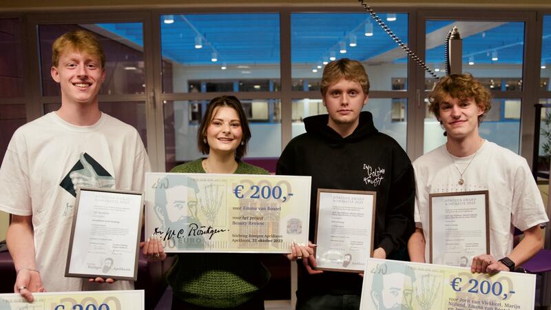Vier winnaars van de Röntgen Award laten trots hun oorkondes en hun cheques ter waarde van € 200 zien