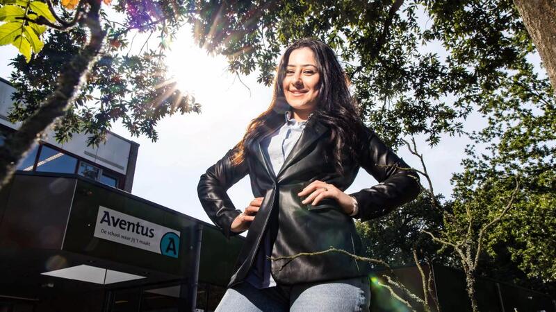 Een Aventus-studente staat vrolijk voor de locatie Middelweg in Deventer