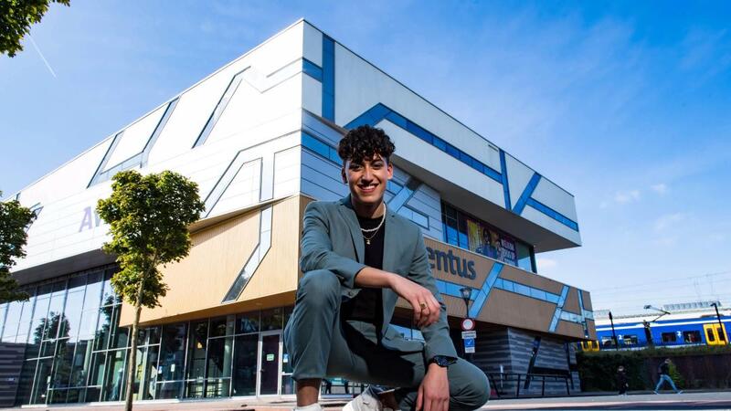 Een Aventus-student staat vrolijk voor de locatie Stationsplein in Zutphen