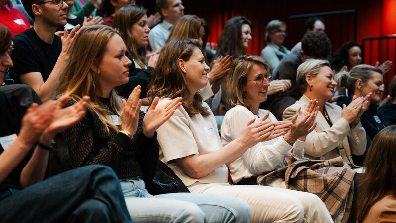 Een zaal met applaudisserende jongvolwassenen