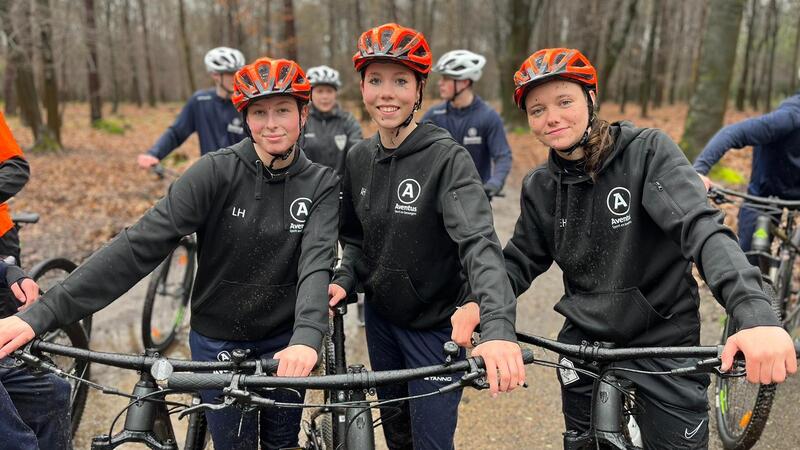 studenten op fietsen die lachen naar de camera