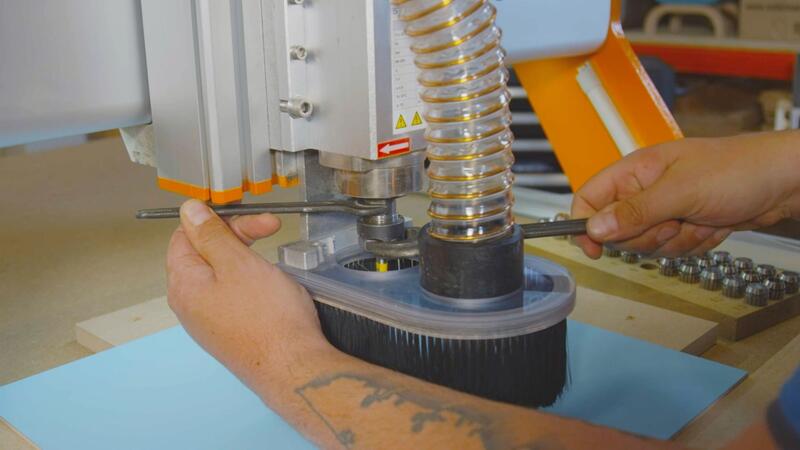 Twee handen monteten iets aan een houtbewerkingsmachine