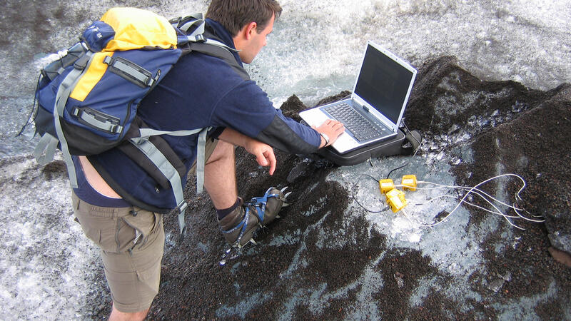 Outdoorstudent in de bergen achter een laptop
