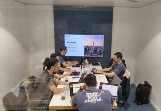 Kantoorruimte een grote tafel met vijf medewerkers van Lodgify achter hun laptop