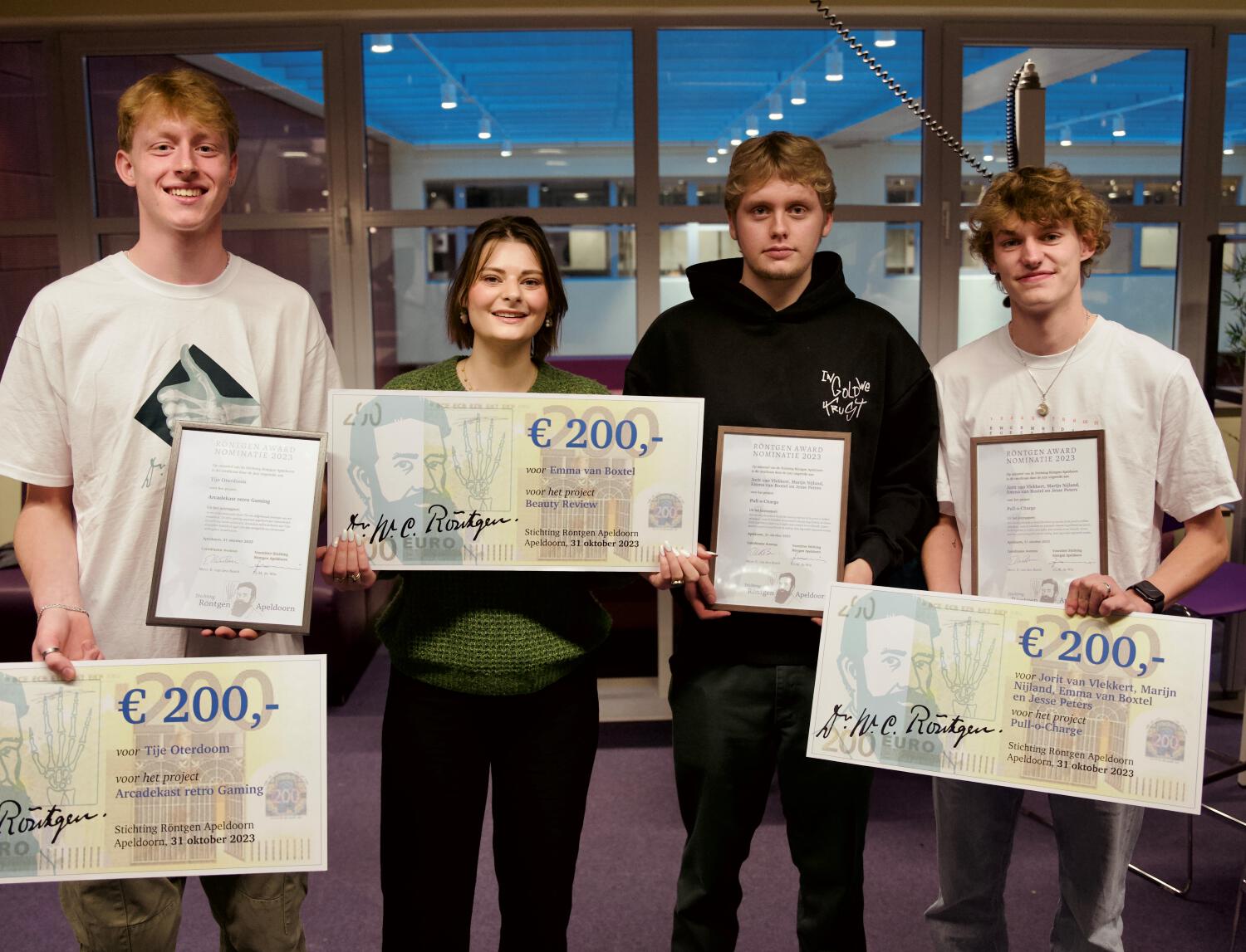Vier winnaars van de Röntgen Award laten trots hun oorkondes en hun cheques ter waarde van € 200 zien