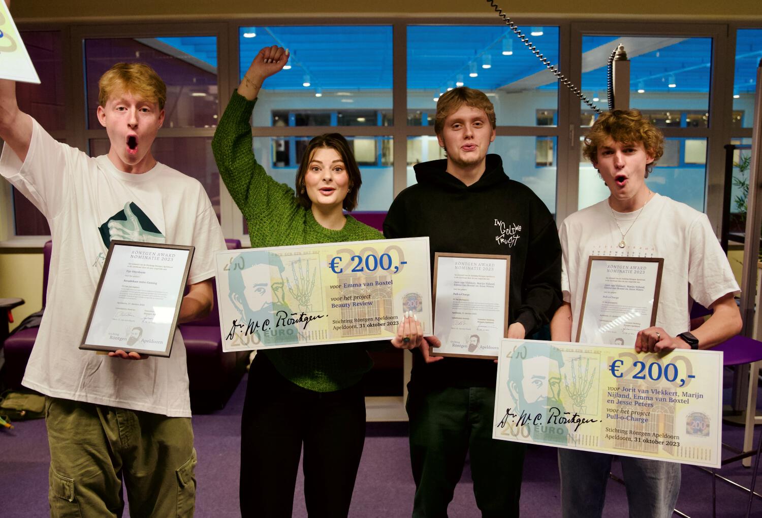 De winnaars van het Röntgen Award juichen met de oorkondes en de cheques in hun handen