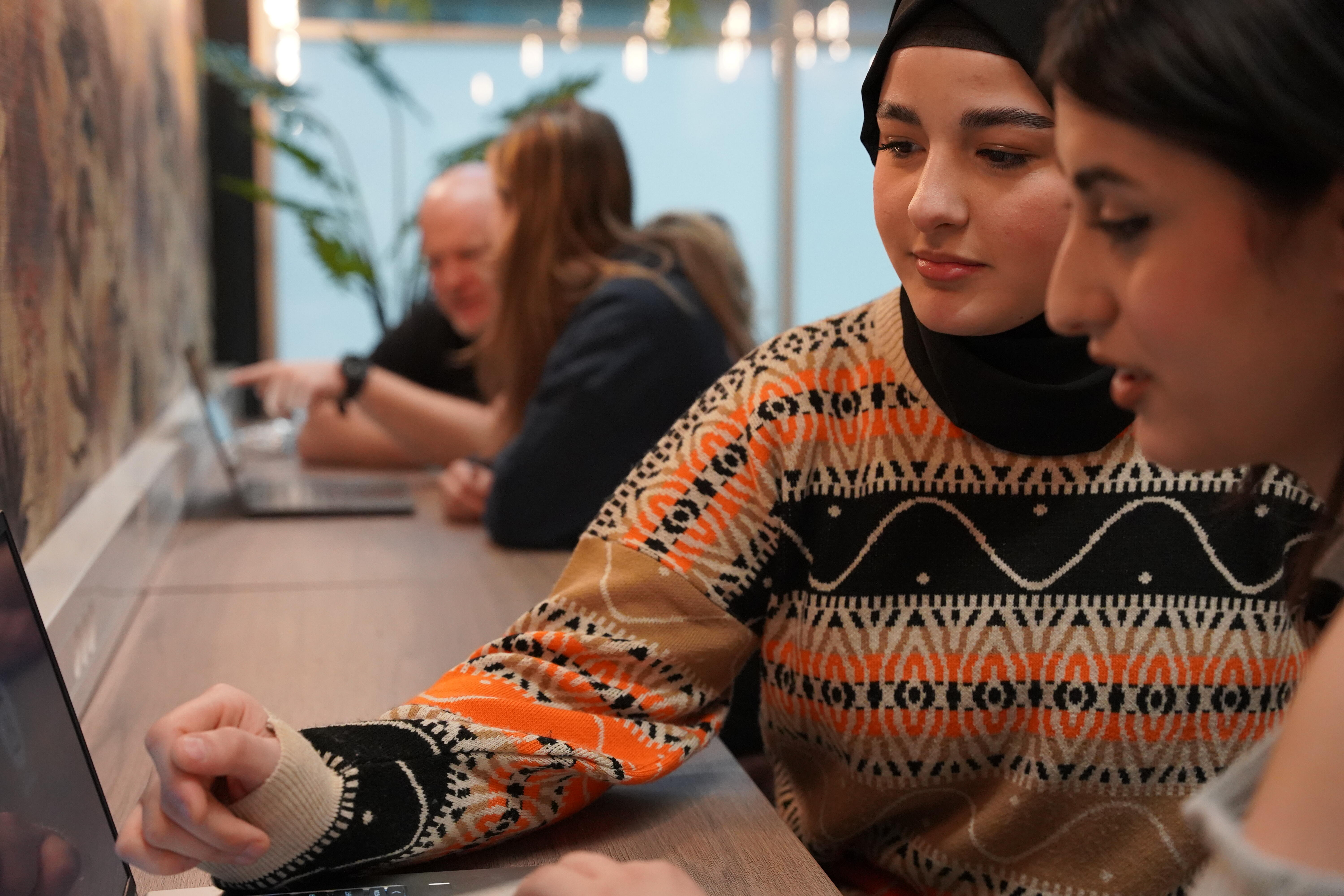 SPEES: Studenten zijn met elkaar in gesprek, een jongerenwerker helpt bij de studie