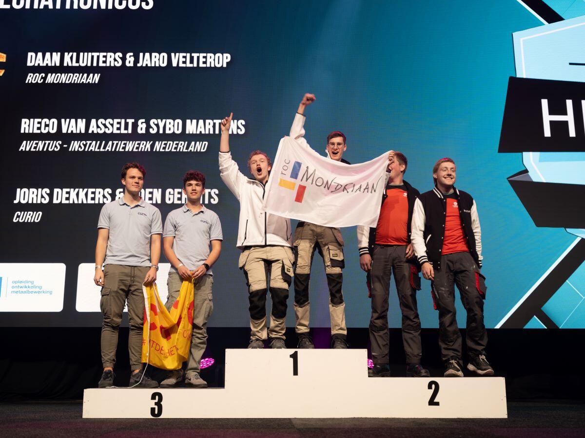 Twee mechatronica-studenten van Aventus staan tijdens Skills the Finals op het poddium vanwege hun zilveren medaille.