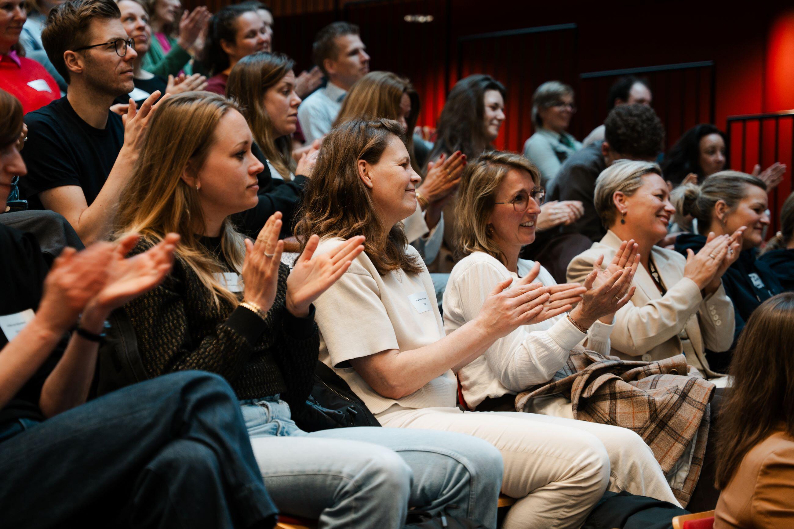 Een zaal met applaudisserende jongvolwassenen
