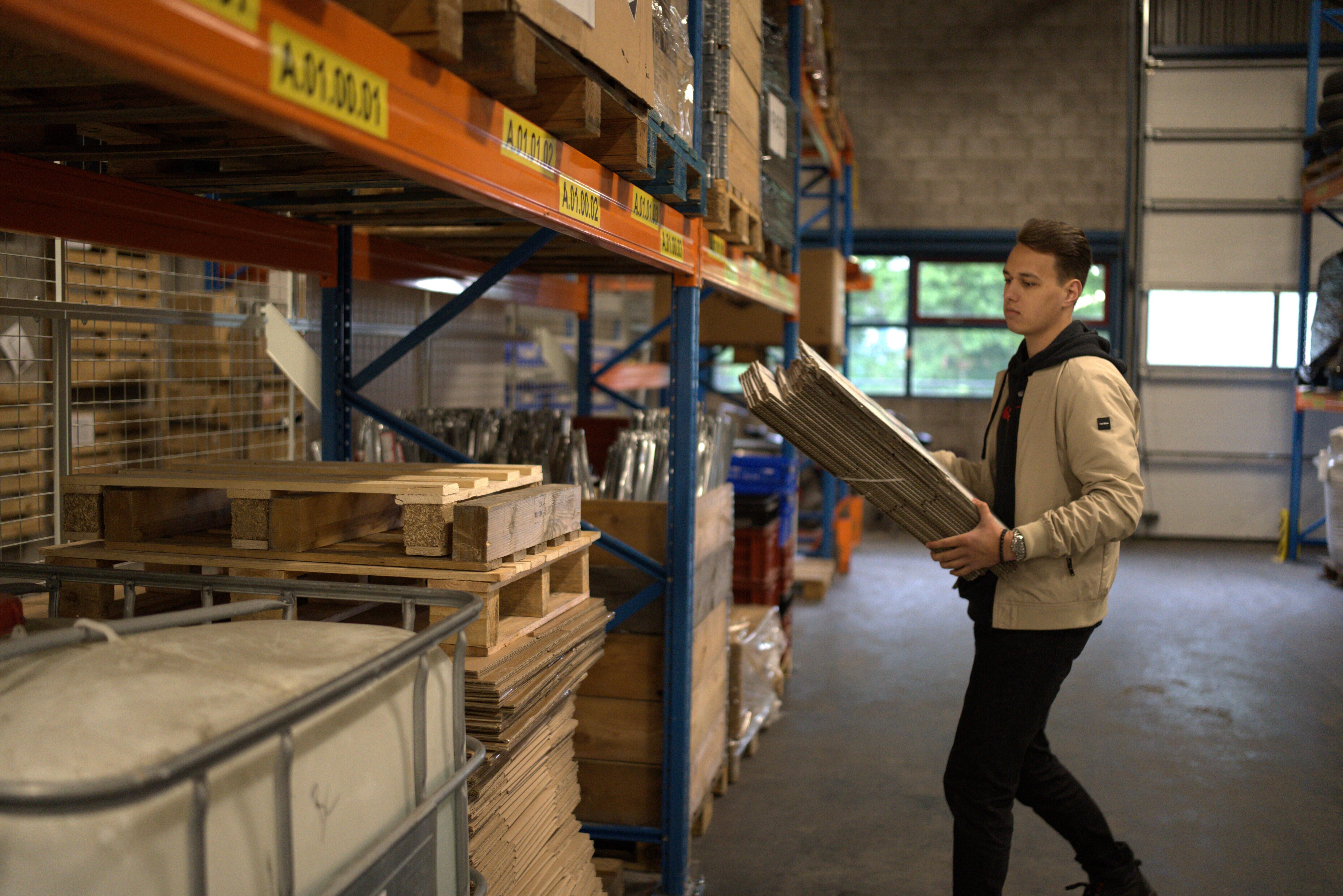 Student met stapel dozen in magazijn