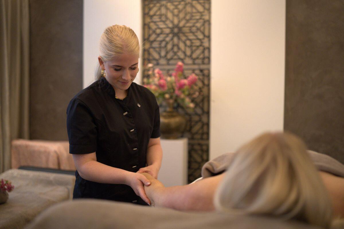 Een jongedame geeft een klant een schoonheidsbehandeling in een salon