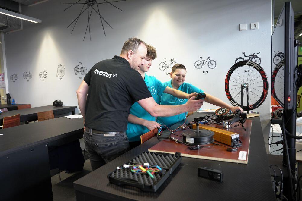 Een docent geeft praktijkles aan studenten fietstechniek