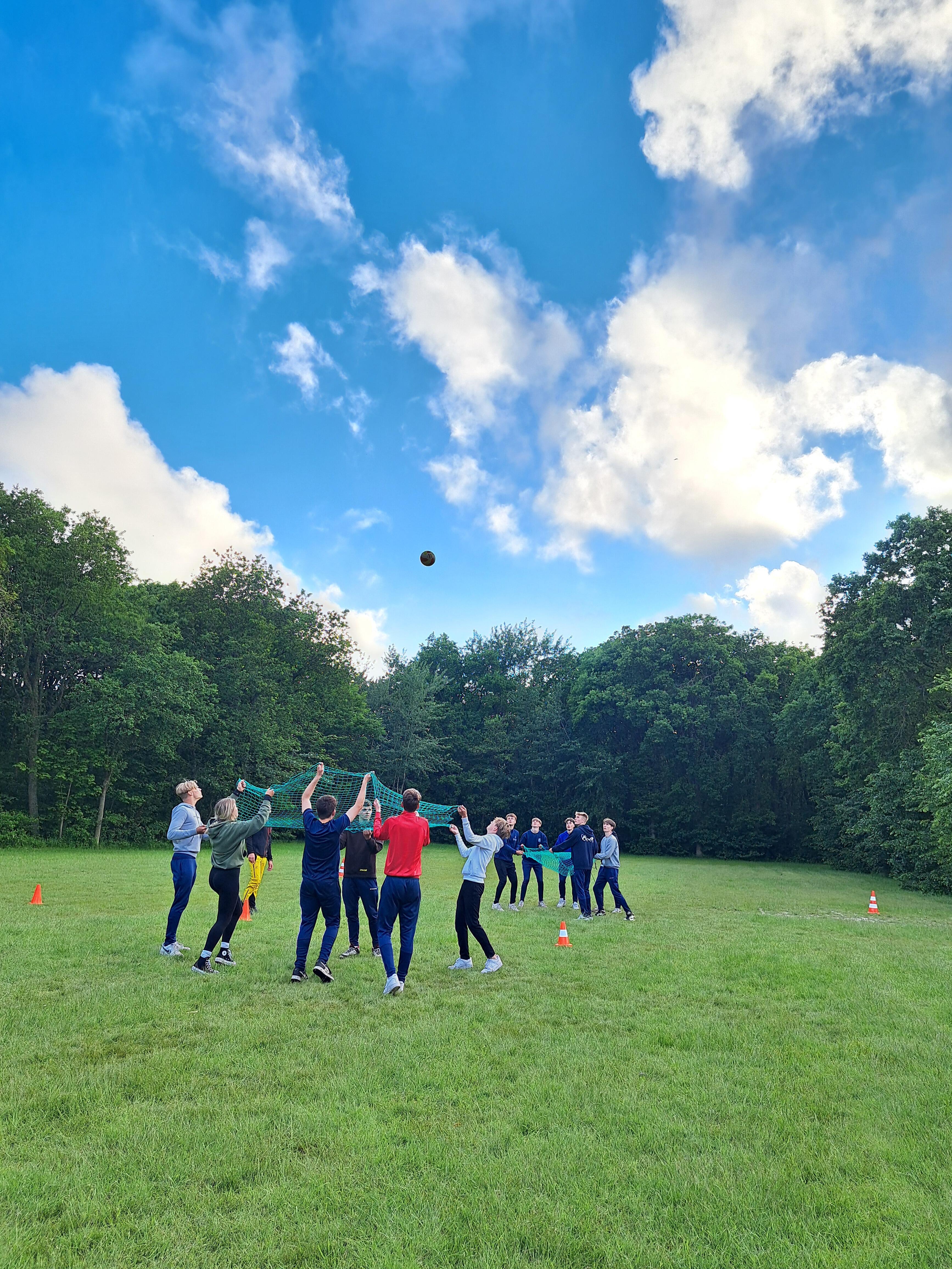 groep studenten die een spel spelen op een grasveld