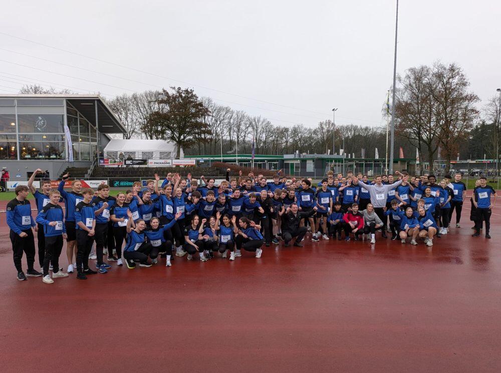 Een groete groep kinderen staat juichend in de gymzaal met de cheque ter waarde van € 1.700
