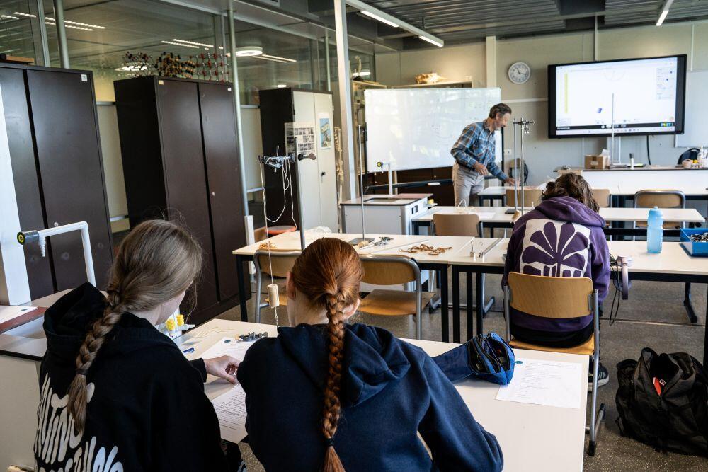 Drie studenten zitten in de scheikundeklas