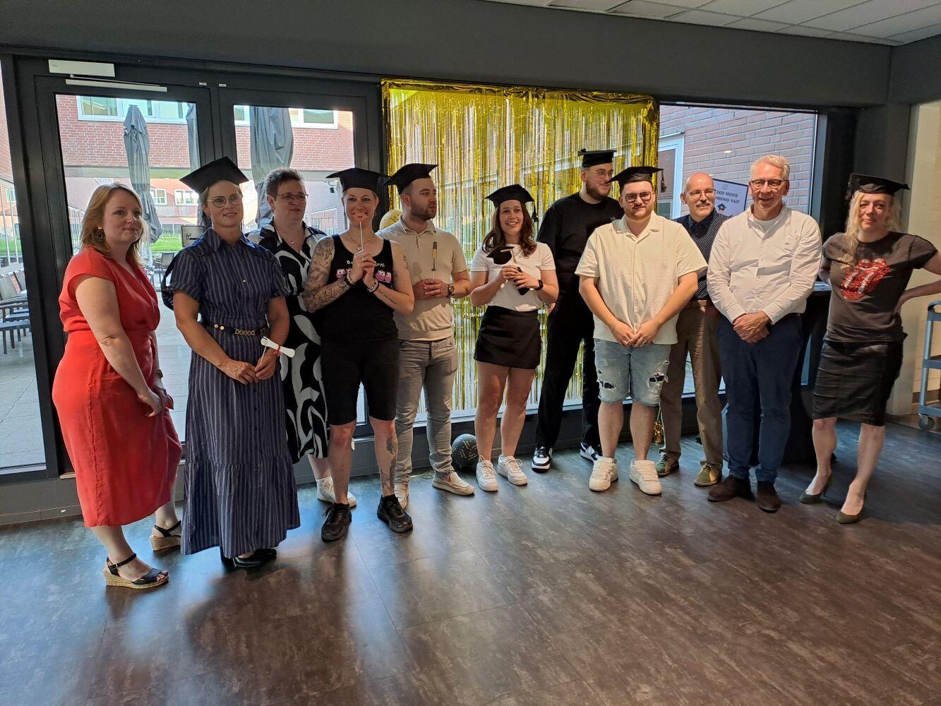 Een blije groep studenten met een afstudeerhoedje