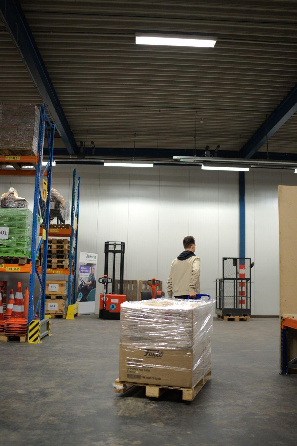 Een pallet met dozen wordt weggereden in een magazijn