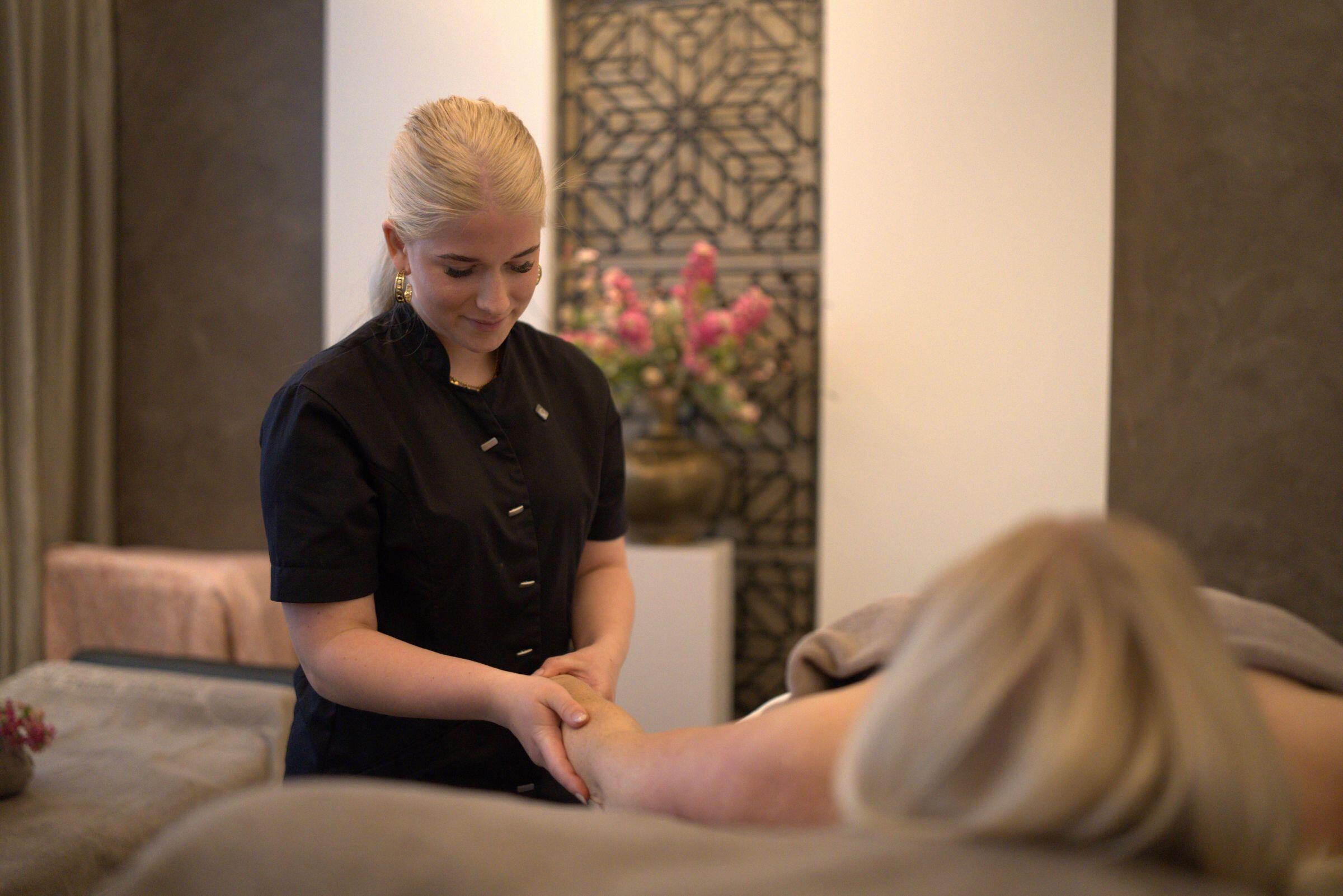 Een medewerker van een schoonheidssalon behandelt een dame