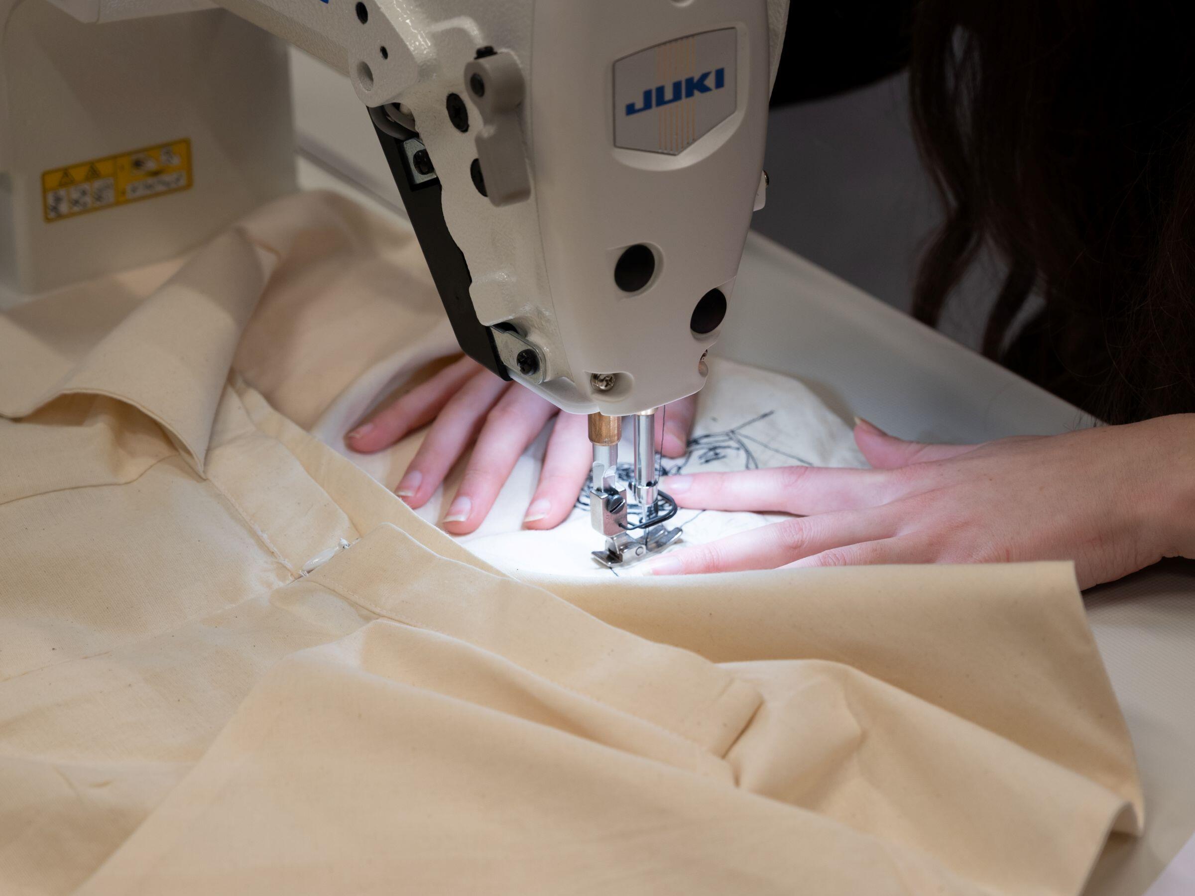 Met een naaimachine wordt een Rembrandt-ontwerp op een kledingstuk aangebracht