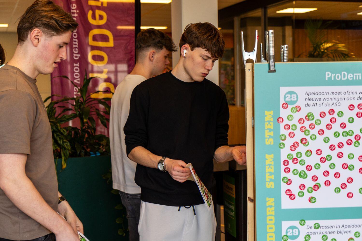 Studenten op het stemplein bij de stickermuur
