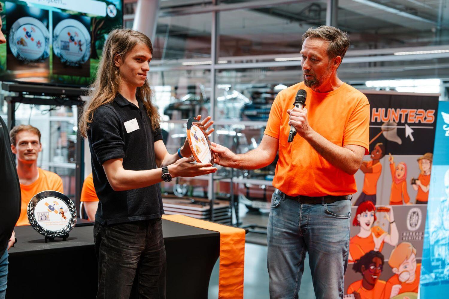 Er wordt een prijs uitgereikt aan een student tijdens Challenge the Cyber