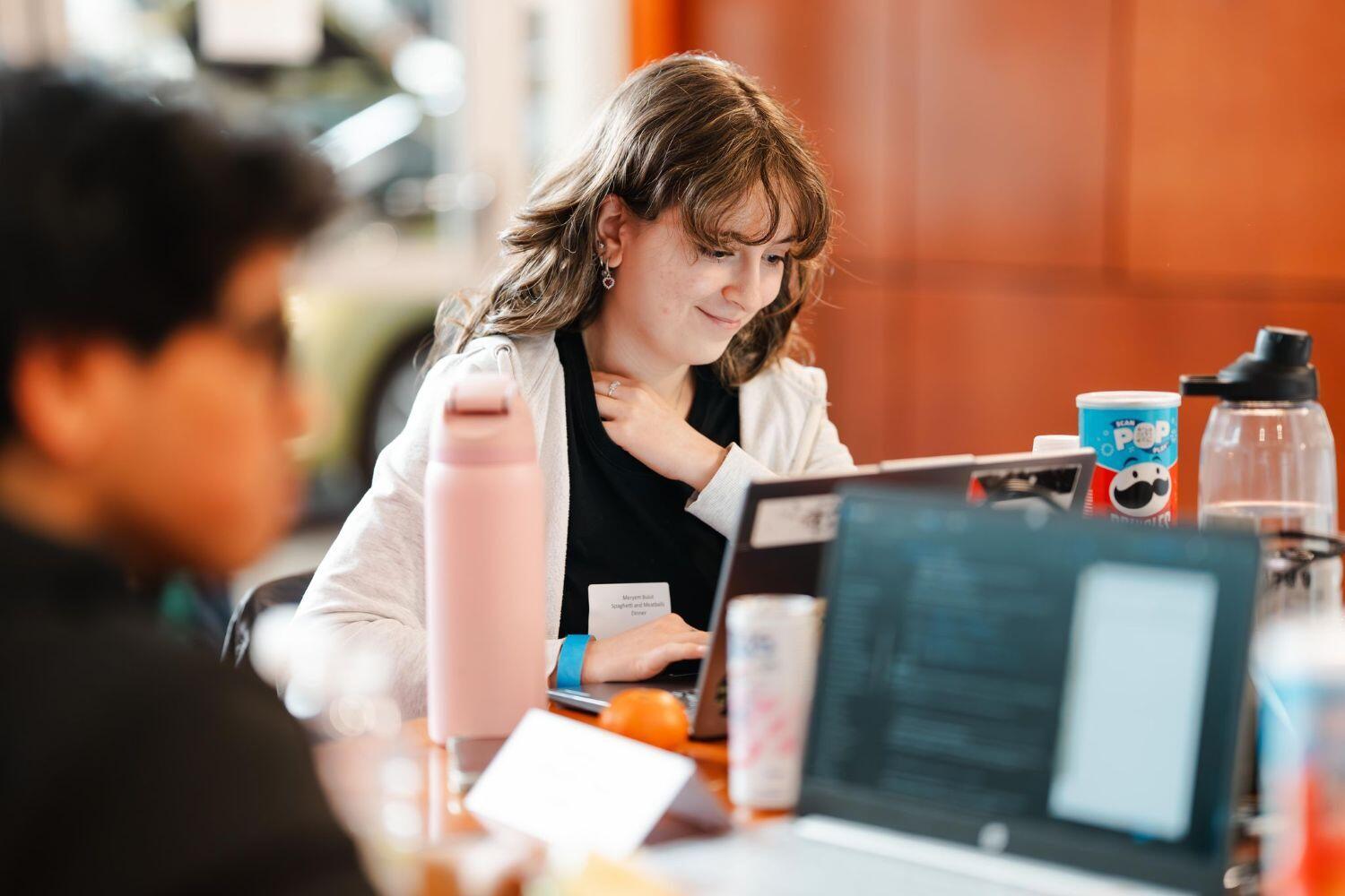 Studente zit achter haar laptop tijdens Challenge the Cyber