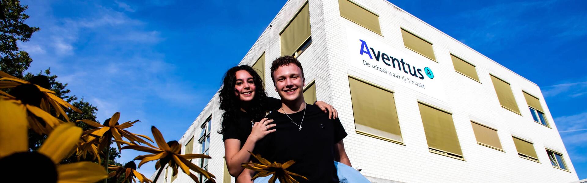 Twee vrolijke Aventus-studenten staan voor de locatie Musschenbroekstraat