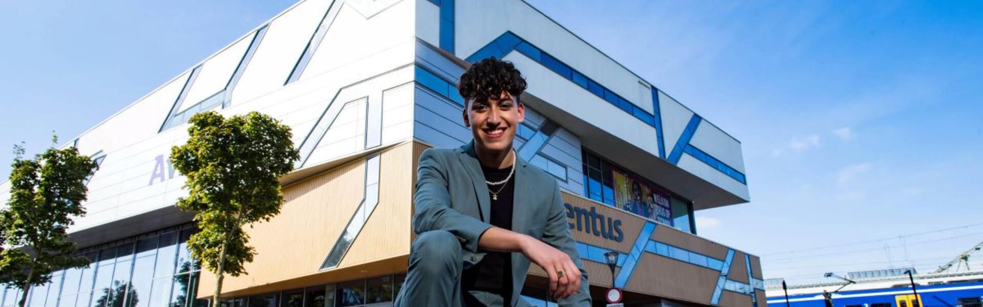 Een Aventus-student staat vrolijk voor de locatie Stationsplein in Zutphen