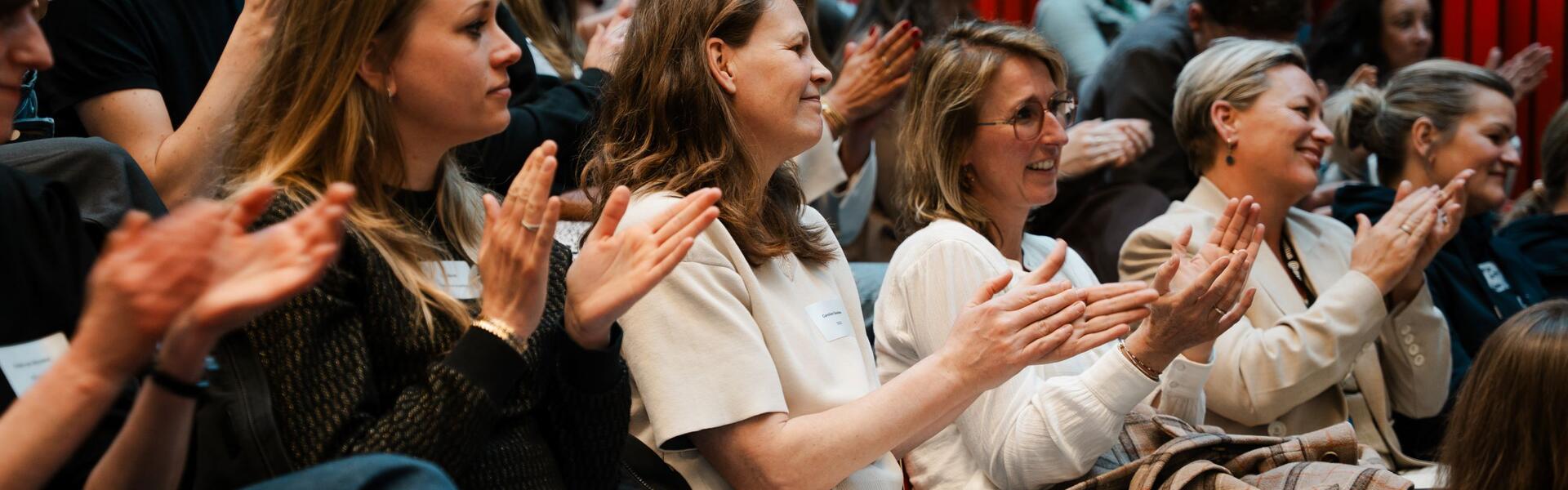 Een zaal met applaudisserende jongvolwassenen