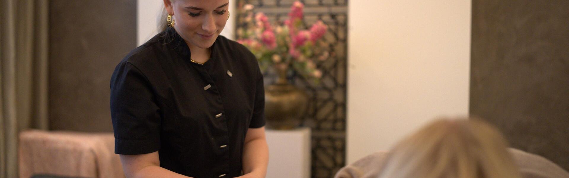 Een medewerker van een schoonheidssalon behandelt een dame