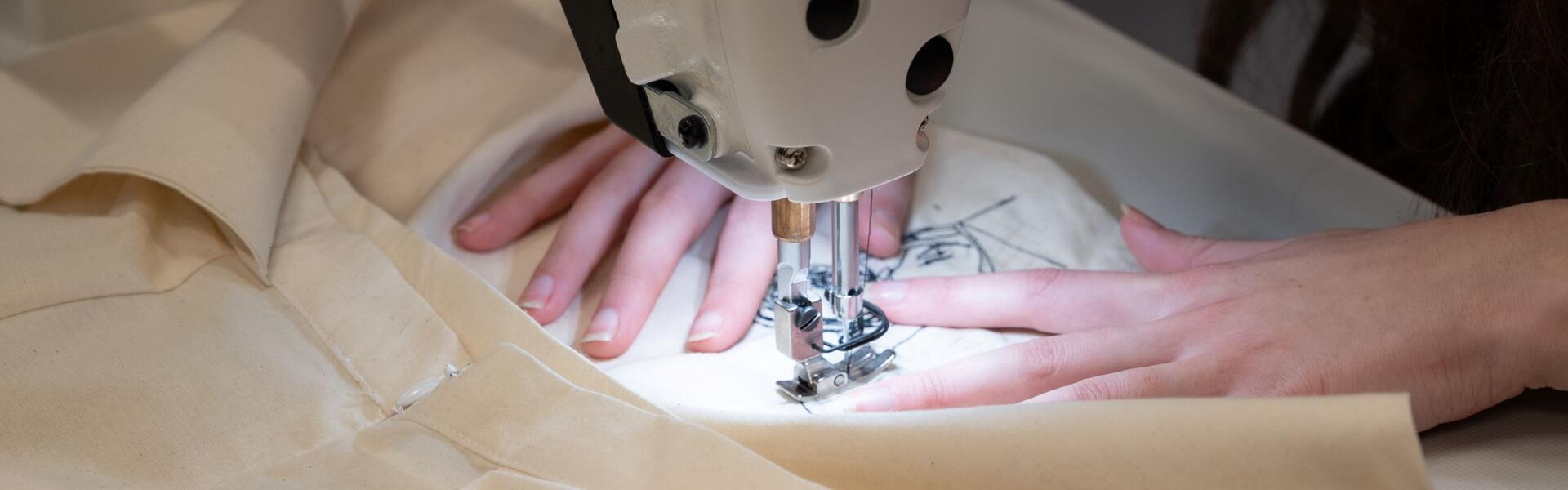 Met een naaimachine wordt een Rembrandt-ontwerp op een kledingstuk aangebracht