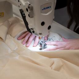 Met een naaimachine wordt een Rembrandt-ontwerp op een kledingstuk aangebracht