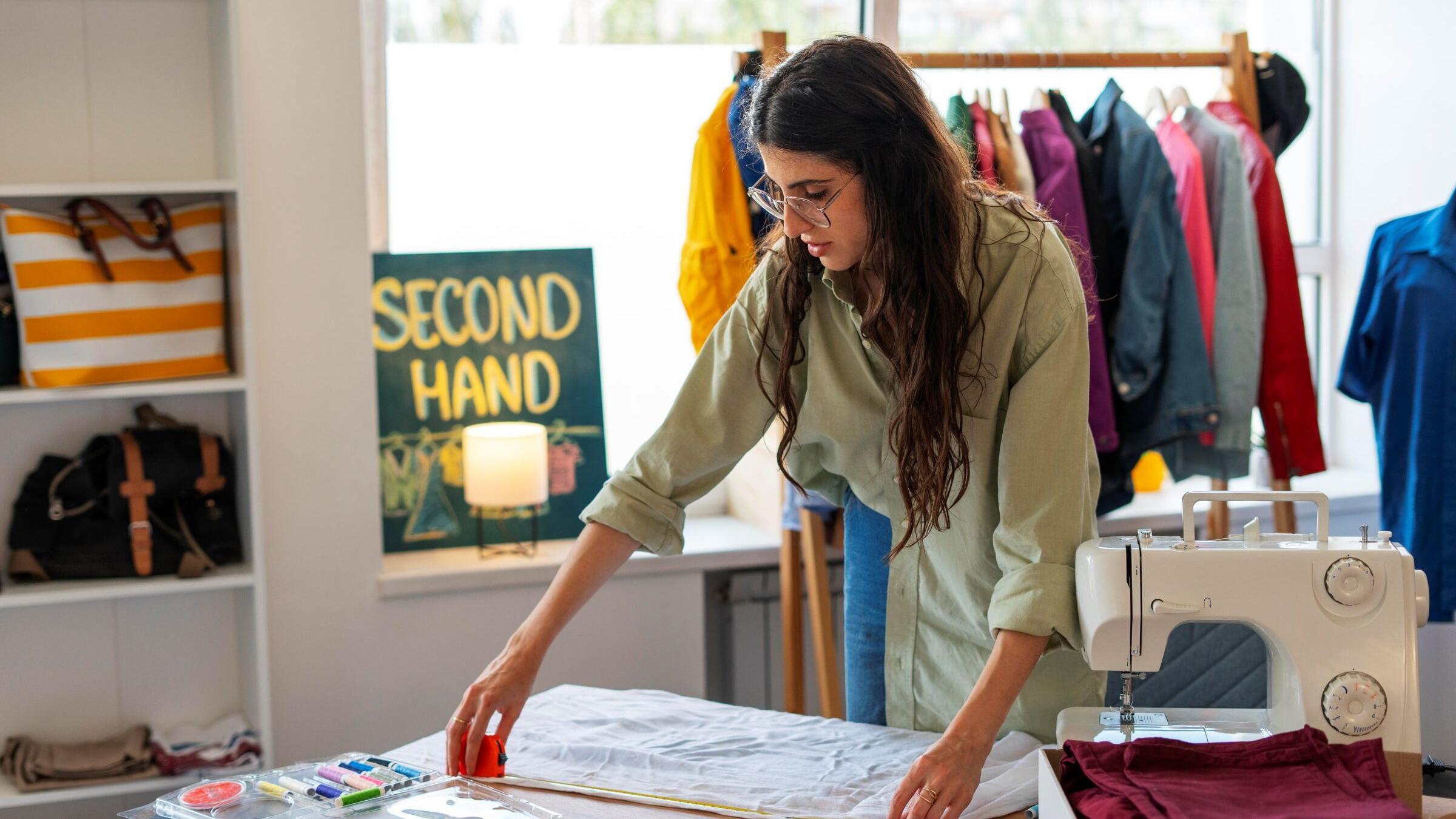 Een jonge vrouw maakt kleding in een atelier
